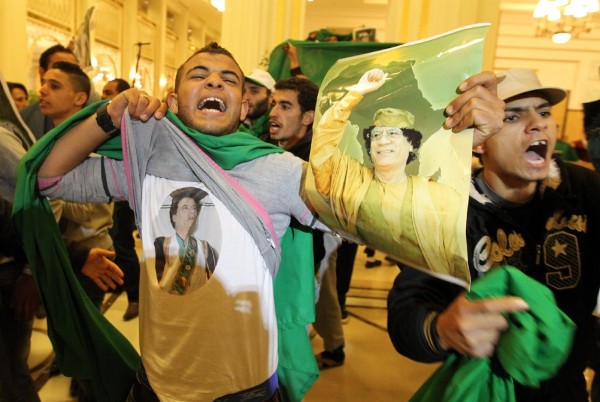 Seguidores del régimen de Muamar el Gadafi muestran camisetas con imágenes del líder libio.