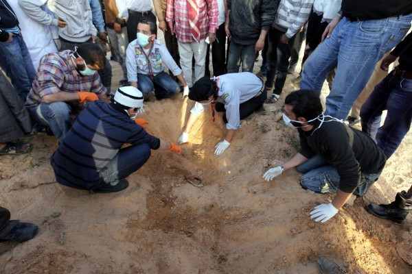 Rebeldes libios buscan el cuerpo de un camarada muerto durante los combates.