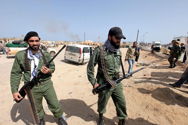 Rebeldes libios se mantienen alerta mientras al fondo asoma el humo procedente de los ataques de las tropas leales al líder libio.