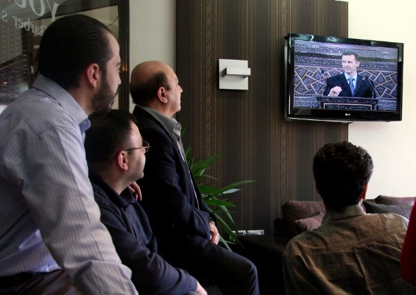 Sirios siguen por televisión el discurso del presidente sirio, Bachar al Asad.