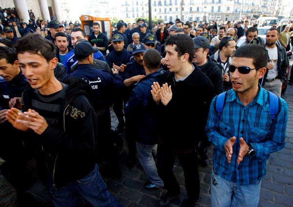 Jóvenes argelinos corean consignas durante una concentración para exigir más puestos de trabajo en el exterior del edificio de Correos en Argel (Argelia).