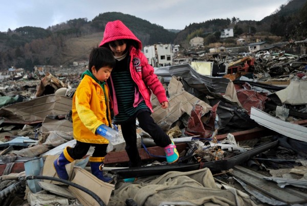 Haruto Asanuma (c) y Shiina Konno, dos primos de cuatro y seis años (respectívamente), localizan los escombros de la casa de su abuela, en Onagawa.