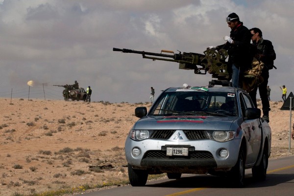 Milicianos rebeldes libios apuntan una pieza de artillería desde una furgoneta 