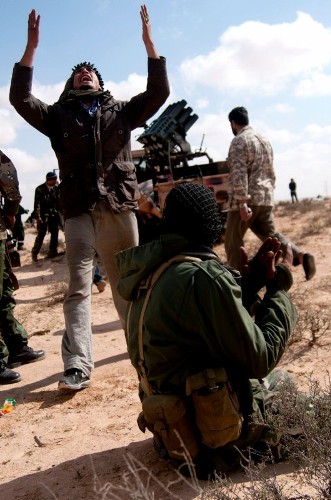 Milicianos rebeldes libios rezan durante los combates.