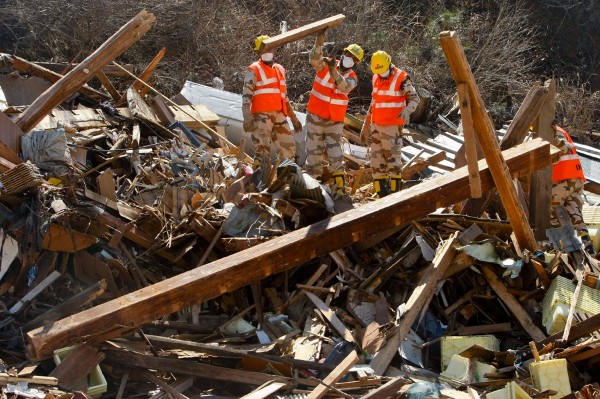 Miembros de los equipos de rescate de la India buscan entre los escombros a los desaparecidos en el tsunami del pasado 11 de marzo de 2011 en la localidad de Onagawa.