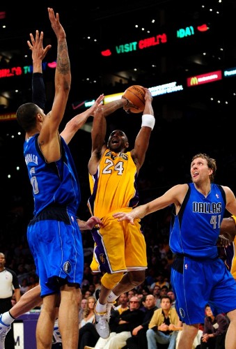 El jugador de Los Ángeles Lakers Kobe Bryant (centro) se disputa el balón con Tyson Chandler (izda) y Dirk Nowitzki (dcha) de los Dallas Mavericks.