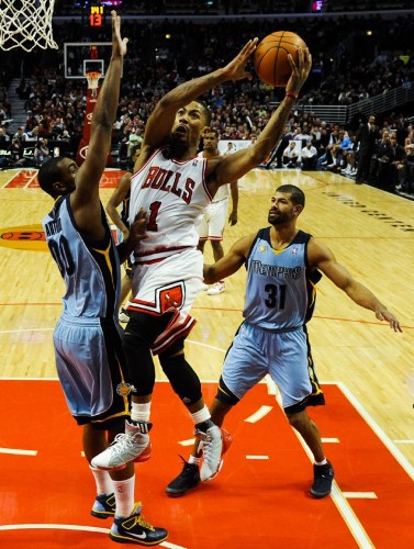 El jugador de Bulls Derrick Rose (c) convierte una cesta ante la marca de Darrell Arthur (i), y Shane Battier (d), de Grizzlies.