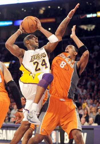 El jugador de los Lakers de Los Angeles Kobe Bryant (izq) entra a canasta a pesar del bloqueo de Channing Frye, de los Suns de Phoenix.