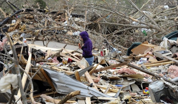 Una mujer camina en medio de una casa destruida en Tushka, Oklahoma.