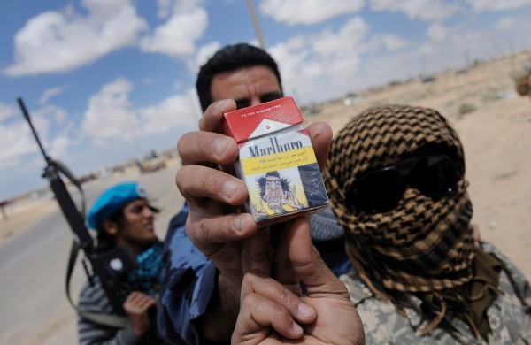Soldados rebeldes libios muestran una cajetilla de cigarrillos con una caricatura que hace una burla al líder libio Muamar el Gadafi.