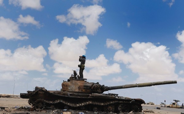 Un soldado rebelde libio permanece encima de un tanque militar que pertenece a las fuerzas leales al líder libio Muamar el Gadafi, en la localidad de Ajdabiya.