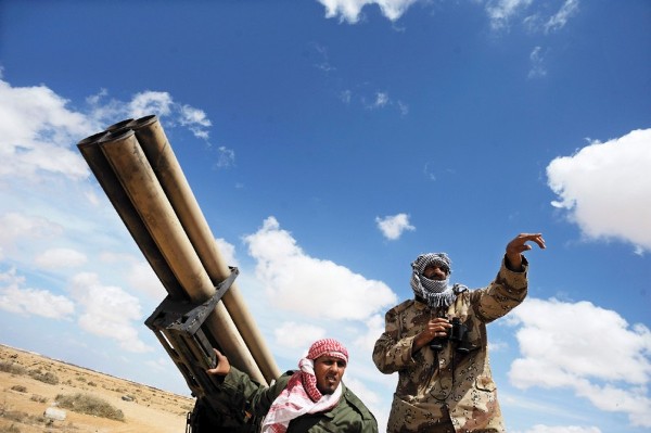 Soldados rebeldes libios conversan detrás de un lanzamisiles en un punto de control en la localidad de Ajdabiya.