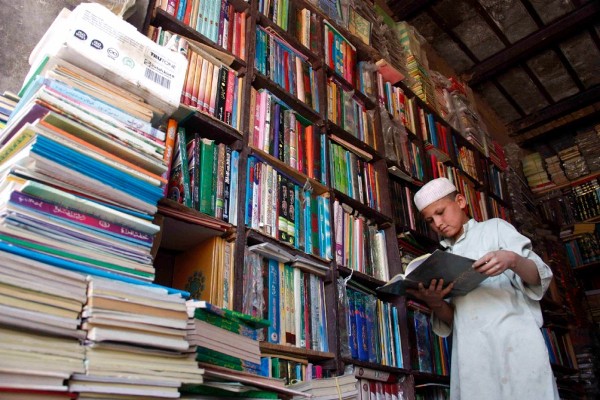 Un niño ojea un libro en una librería en Chaman (Pakistán) en la víspera de celebración del Día del Libro.