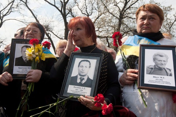 Un grupo de mujeres ucranianas porta retratos de sus familiares muertos tras el desastre nuclear en la central nuclear de Chernóbil.