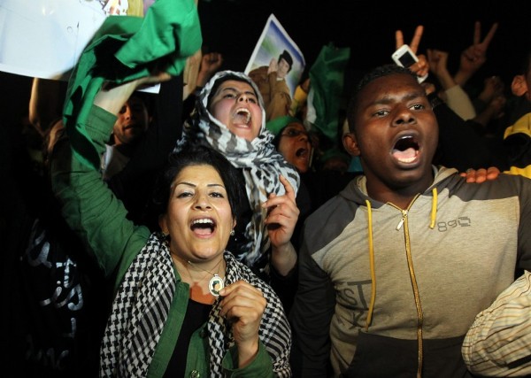 Varias personas, leales al líder libio Muammar el Gaddafi, gritan consignas en su apoyo.
