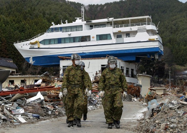 Efectivos de las Fuerzas de Autodefensa japonesas buscan personas desaparecidas entre los escombros.