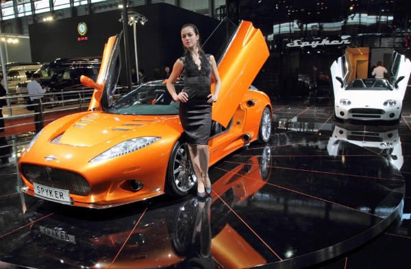 Una modelo posa delante del Spyker C8 expuesto en el 14º Salón del Automóvil de Shanghaí (China).