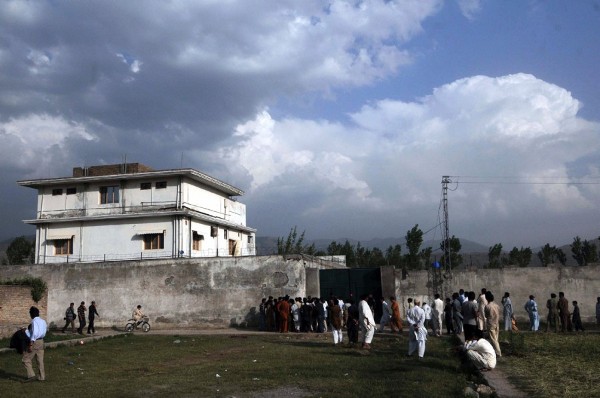 Periodistas y vecinos se reunen en el exterior de la vivienda en la que murió Osama Bin Laden durante una operación militar estadounidense.
