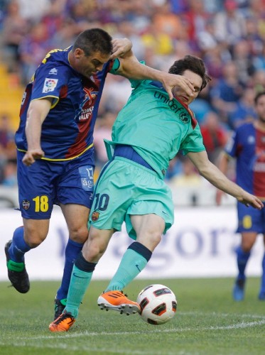 El defensa del Levante, Ballesteros (i), corta el avance del delantero del F. C. Barcelona, Leo Messi, durante el encuentro correspondiente a la vigésimo sexta jornada de primera división, que ambos equipos disputan esta noche en el estadio Ciutat de Valencia.