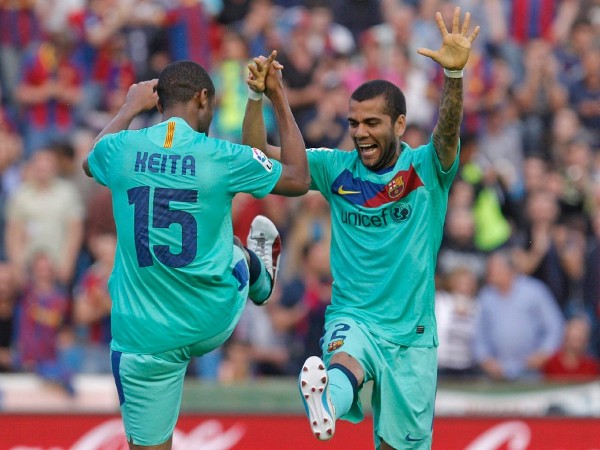 Los jugadores del F. C. Barcelona, el malí Keita (i) y el brasileño Dani Alves, celebran el primer gol del equipo barcelonista, durante el encuentro correspondiente a la vigésimo sexta jornada de primera división, que les enfrenta esta noche al Levante en el estadio Ciutat de Valencia.