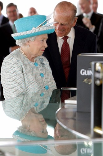 La reina Isabel II de Inglaterra (izq) y el príncipe Felipe (2º izq), duque de Edimburgo, son agasajados con una pinta de cerveza Guinness.