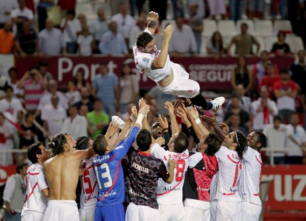 Los jugadores de Sevilla lanzan al aire a Dragutinovic.