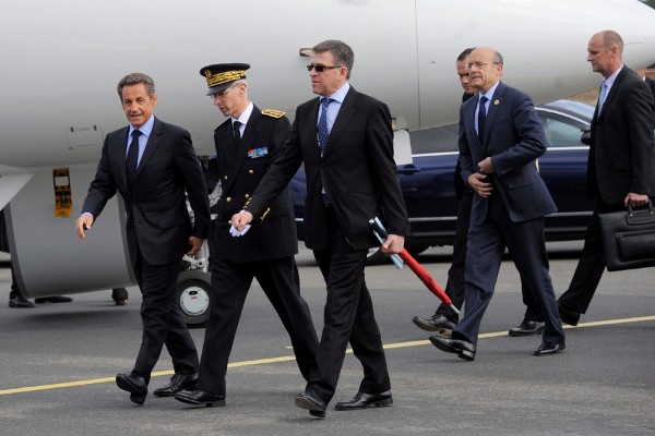 El presidente francés, Nicolas Sarkozy (izq), el ministro de Exteriores fran¿ces, Alain Juppe (2º dcha), y el prefecto de Basse-Normandie, Didier Lallemend (2º izq), a su llegada al aeropuerto de Saint-Gatien.