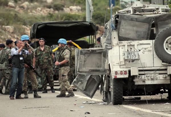 Soldados libaneses y de las Fuerzas Interina de Naciones Unidas en Líbano (FINUL), junto al vehículo que sufrió el atentado.