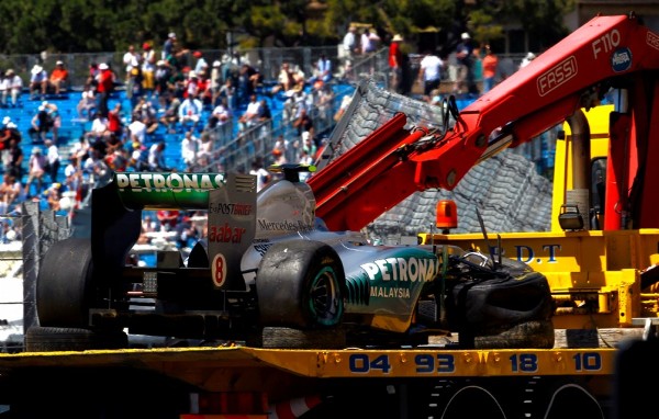 Una grúa retira el coche averiado del piloto alemán Nico Rosberg, de la escudería Mercedes GP.