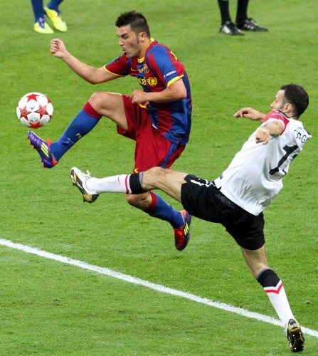El jugador del FC Barcelona David Villa (i) disputa el balón con Ryan Giggs (d), del Manchester United, hoy, sábado 28 de mayo de 2011, durante la final de la Liga de Campeones de la UEFA en el estadio de Wembley en Londres (Reino Unido).