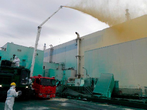 Fotografía tomada el 27 de mayo de 2011, facilitada por la compaía Tokyo Electric Power Co (TEPCO) que muestra a trabajadores esparciendo un spray anti polvo en la central nuclear de Fukushima (Japón).