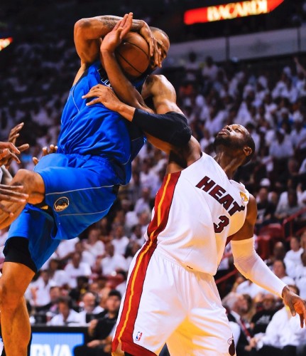 El jugador de los Heat de Miami Dwyane Wade (dcha) lucha por el balón con Tyson Chandler.