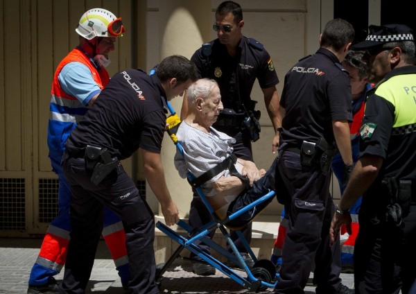 Sanitarios y policías evacúan a uno de los residentes del edificio de la calle Brasil de Cádiz.