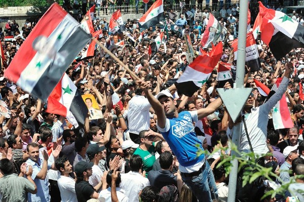Seguidores del presidente sirio Bachar al Asad agitando banderas sirias en Damasco.
