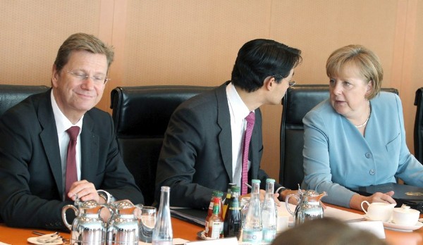La canciller alemana, Angela Merkel (i), conversa con el ministro de Economía, Philipp Roesler (c), en presencia del ministro de Exteriores, Guido Westerwelle, durante la reunión de Gabinete de Gobierno celebrada en la Cancillería en Berlín (Alemania), hoy, miércoles 22 de junio de 2011.