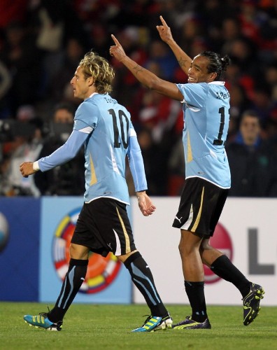 El jugador de la selección de Uruguay de fútbol Álvaro Pereira (der) festeja su gol junto a Diego Forlán (izq).