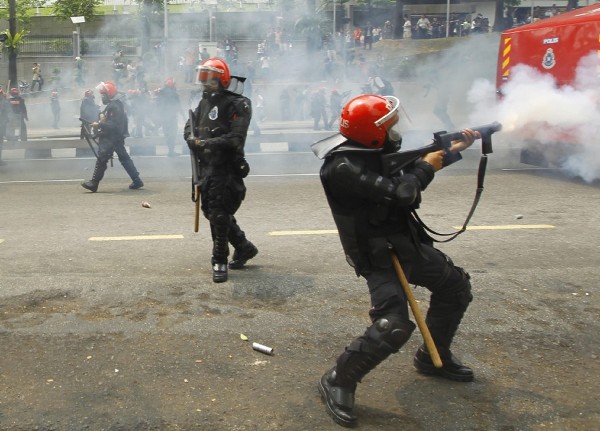 Efectivos de la Policía malasia disparan gases lacrimógenos durante un choque con manifestantes.