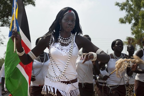 Una bailarina profesional de Sudán del Sur sostiene una bandera durante las celebraciones con música y baile en las calles de Yuba.