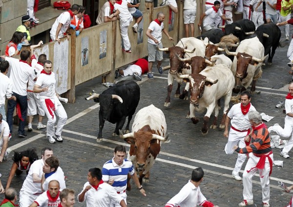 Los toros de la ganadería sevillana de Dolores Aguirre entran en manada compacta en el tramo del Ayuntamiento durante el tercer encierro de los sanfermines.