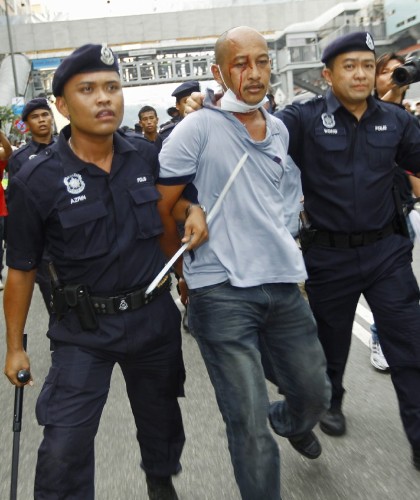Efectivos de la Policía malasia detienen a un hombre durante un choque con manifestantes.