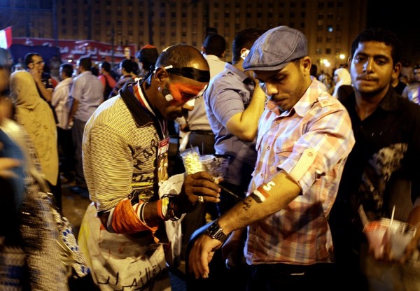 Egipcios se pintan banderas nacionales en la plaza Tahrir de El Cairo (Egipto).