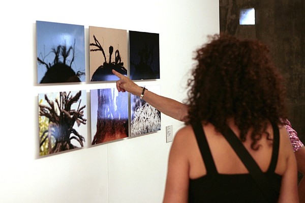 Dos personas observan una de las fotografías de la exposición.