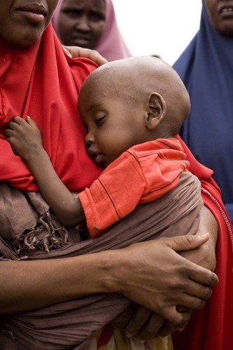 Fotografía distribuída el día 25 de julio de 2011 por la agencia de Naciones Unidas WFP, en la que se ve a un niño llevado por su madre tras llegar a Mogadiscio.