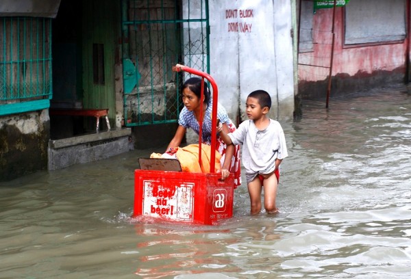 Unos niños filipinos se abren camino en una calle inundada en la localidad de Cotabato, en el sur de Filipinas.