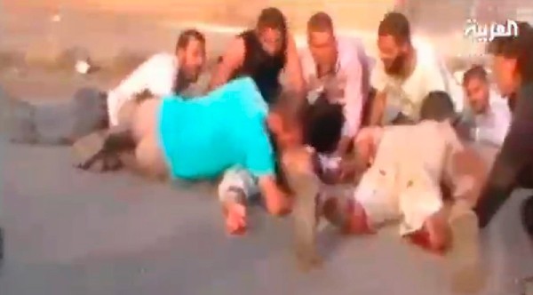 Fotograma tomado del canal de televisión Al Arabiya hoy, martes 2 de agosto de 2011 que muestra a varios manifestantes sirios mientras rodean a un hombre herido después que que las tropas sirias asaltaran la ciudad siria de Abu Kamal, cerca de la frontera iraquí. 