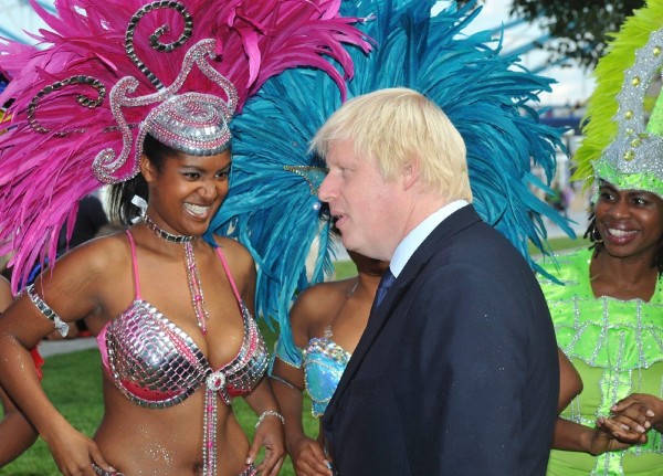 El alcalde conservador de Londres, Boris Johnson (c), habla con las reinas del carnaval del grupo musical Genesis.