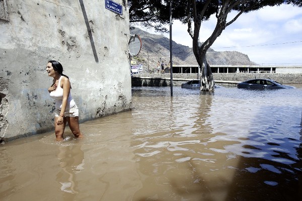 Una mujer camina por una calle inundada.