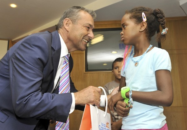 El presidente del Gobierno de Canarias, Paulino Rivero, le entrega un regalo a una niña saharaui.