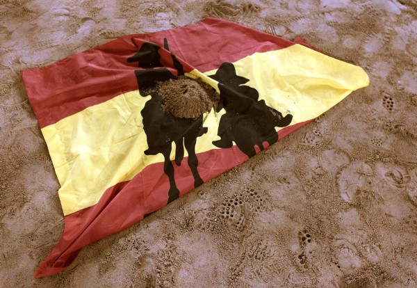 Una bandera de España con las siluetas de El Quijote y Sancho Panza fue dejada sobre la arena del ruedo de la Monumental.