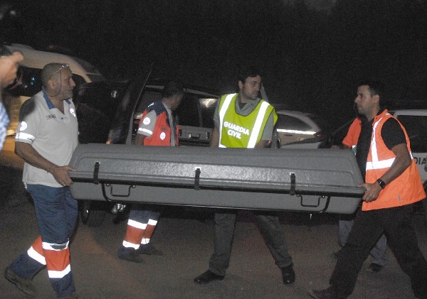 Miembros de protección civil y de la guardia civil, trasladan el cuerpo sin vida del piloto.